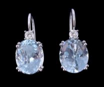 A pair of aquamarine and diamond earrings, the oval cut aquamarines claw set below a brilliant cut