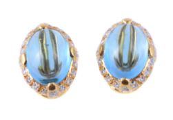 A pair of blue topaz and diamond earrings, the oval cabochon blue topaz within a surround of