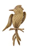 A 1960s French gold bird brooch, the exotic bird perched on a branch, with textured feathers and a