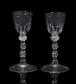 A pair of balustroid wine glasses, mid 18th century, the round funnel bowls supported on triple-