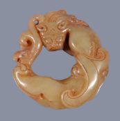 A Chinese celadon and russet carved jade chilong , 4.6cm diameter Provenance: Property from a