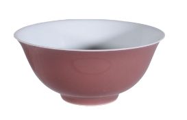 A Chinese copper-red bowl, the deep flaring sides supported on a short foot, the exterior covered