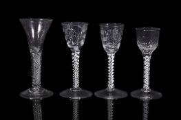 A pair of opaque-twist wine glasses, circa 1760, the round funnel bowls engraved and polished with