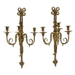 A pair of substantial polished brass three light wall appliques in Louis XVI style, early 20th