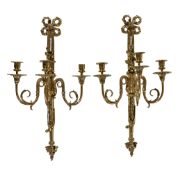 A pair of substantial polished brass three light wall appliques in Louis XVI style, early 20th