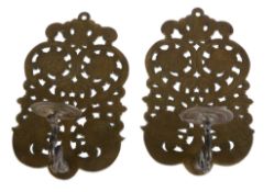 A pair of brass wall appliques in 17th century style, early 20th century, the sockets on scrolling