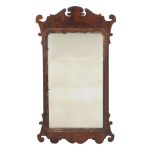 A George III walnut fretwork wall mirror, circa 1770, with parcel gilt slip, 87cm high, 50cm wide