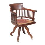 An Edwardian mahogany revolving desk chair , circa 1910, with spindles to the back