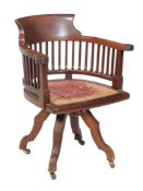 An Edwardian mahogany revolving desk chair , circa 1910, with spindles to the back