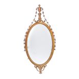 A giltwood and composition oval wall mirror after the manner of Robert Adam , the oval plate