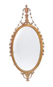 A giltwood and composition oval wall mirror after the manner of Robert Adam , the oval plate