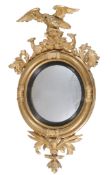 A George III carved giltwood circular convex wall mirror, circa 1810, the circular plate within an