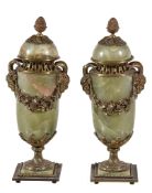 A pair of French onyx and gilt bronze mounted urns and covers, late 19th century, the domed lids