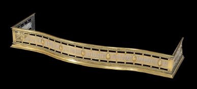 A Regency brass fender, circa 1815, the bowfront and side returns with pierced fluting, beading and