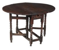 An oak drop leaf table , mid-17th century, with bobbin turned supports, 69cm high, 91cm wide, 103cm