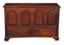A George III oak mule chest, circa 1770, with fluted angles flanking the moulded quadruple panel
