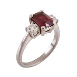 A ruby and diamond three stone ring, the step cut ruby flanked by brilliant cut diamonds,