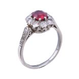 A 1930s ruby and diamond cluster ring, the oval cut ruby estimated to weigh 0.61 carats within a