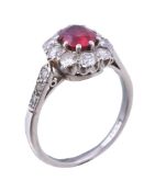 A 1930s ruby and diamond cluster ring, the oval cut ruby estimated to weigh 0.61 carats within a