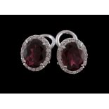 A pair of rhodolite garnet and diamond earrings, the oval cut rhodolite garnet claw set within a