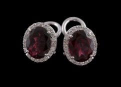 A pair of rhodolite garnet and diamond earrings, the oval cut rhodolite garnet claw set within a