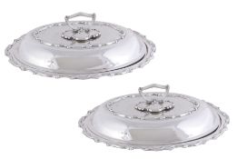 A pair of late Victorian silver shaped oval entree dishes, covers and handles by William Hutton &