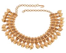 An Indian gold coloured necklace, the beaded necklet with red enamelled quatrefoil flowerhead