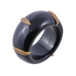 An onyx & yellow sapphire bangle, the polished onyx band with applied navette shaped gold coloured