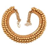 An Indian gold coloured necklace, the articulated panels with polished and quatrefoil decoration,