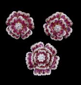 A pair of ruby and diamond earrings, designed as flower heads, set with oval cut rubies and