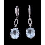 A pair of aquamarine and diamond earrings, the oval cut aquamarine claw set below a panel of