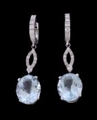 A pair of aquamarine and diamond earrings, the oval cut aquamarine claw set below a panel of