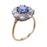 A sapphire and diamond ring, the oval cut sapphire claw set within a surround of brilliant cut