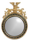 A Regency ebonised and gilt oval convex wall mirror, circa 1815, the oval plate within an ebonised