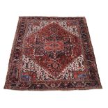 A Heriz carpet , decorated throughout with geometric foliate motifs, the central navy, sky blue and