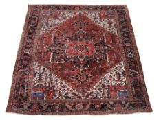 A Heriz carpet , decorated throughout with geometric foliate motifs, the central navy, sky blue and