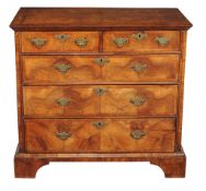 A George I walnut and featherbanded chest of drawers , circa 1720, bookmatched veneers throughout,