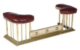A gilt brass and leather upholstered club fender, 20th century, the kidney shaped rests above