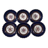 Six Worcester blue-ground plates, circa 1770 , the centres painted with floral sprays within gilt