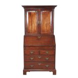 A George II mahogany bureau cabinet, circa 1750, the moulded cornice above a pair of panelled doors