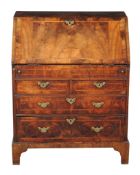 A George I walnut and featherbanded bureau, circa 1720, the rectangular fall opening to a leather