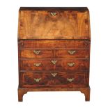 A George I walnut and featherbanded bureau, circa 1720, the rectangular fall opening to a leather