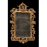 A pair of George III carved giltwood wall mirrors, circa 1780, each shaped rectangular plate within
