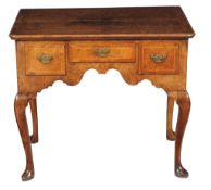 A George II walnut and ash crossbanded side table, circa 1735, the quarter veneered top within a