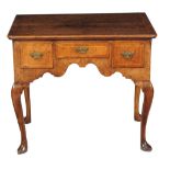 A George II walnut and ash crossbanded side table, circa 1735, the quarter veneered top within a