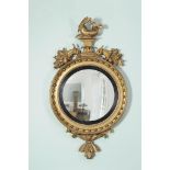 A George III giltwood circular convex wall mirror , circa 1810, the plate and reeded sight edge
