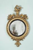 A George III giltwood circular convex wall mirror , circa 1810, the plate and reeded sight edge
