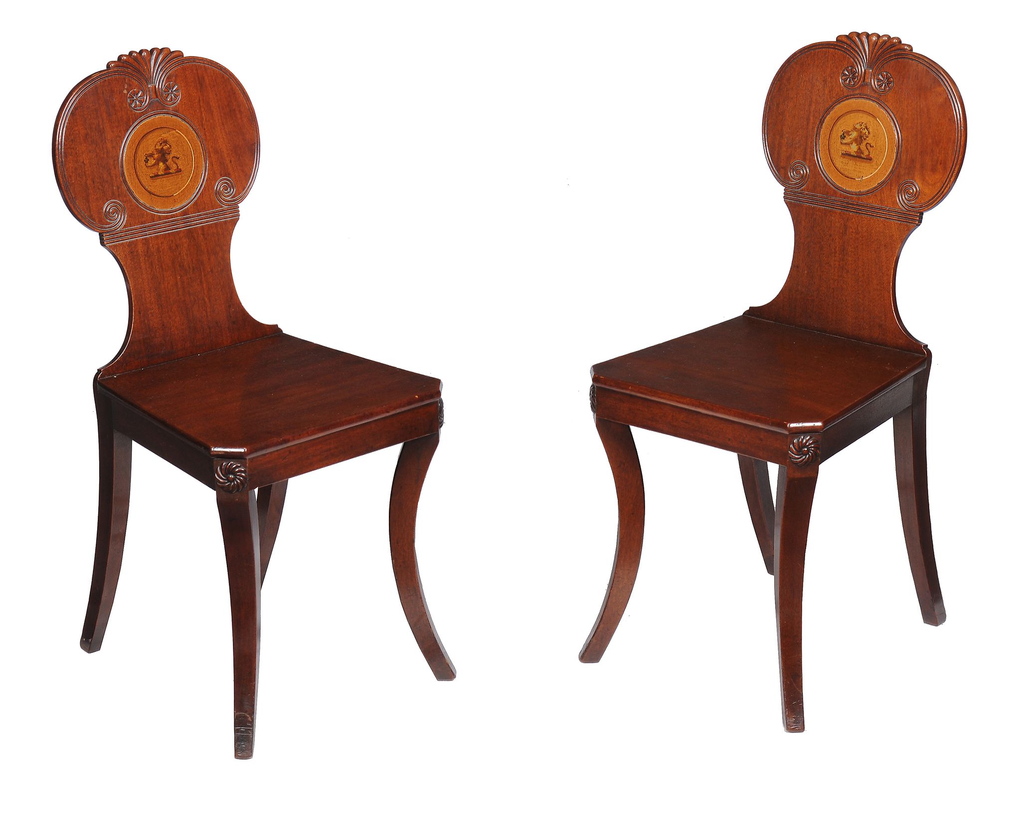 A pair of Regency mahogany hall chairs , circa 1815, each with shaped lobed and scrolled back with