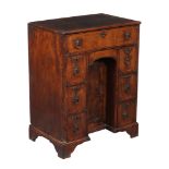 A George II walnut and featherbanded kneehole desk, circa 1740, the quarter veneered, banded and