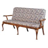A George I walnut and upholstered settee, circa 1720, the shaped rectangular back and seat flanked